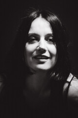 Fototapeta premium Sensual portrait of a woman with dark hair, done in a low key style.