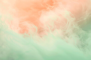 Pastel tones of peach and mint with wispy clouds in an ethereal abstract blur.