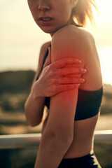 Woman, shoulder and pain in red from outdoor training, fitness and muscle injury as athlete. Sport,...