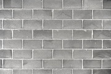 Concrete brick wall with light-colored cement to bond them all.