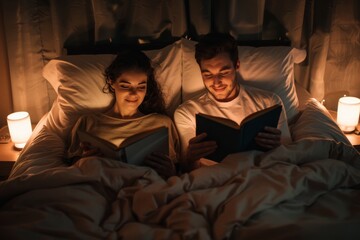 In a dimly lit room, a couple is absorbed in reading books by candlelight, creating a cozy atmosphere