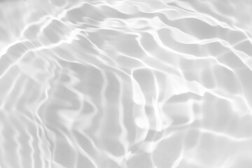 White water with ripples on the surface. Defocus blurred transparent white colored clear calm water surface texture with splashes and bubbles. Water waves with shining pattern texture background.