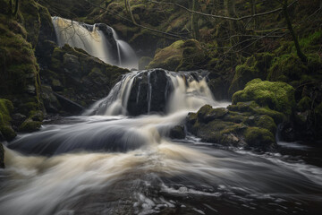 Fototapeta premium there is a waterfall that is flowing down a mountain side