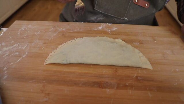 a male chef makes kutab dough in a home kitchen