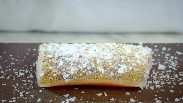 The cook prepares zander, pikeperch fillet. Raw zander is sprinkled with pepper before frying. Slow motion, 4k, 100 fps video.