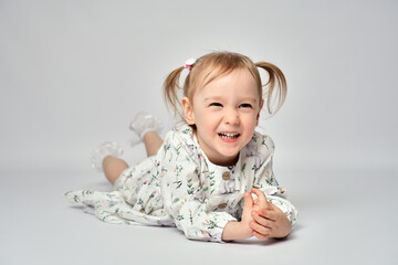 Close-up portrait of cute little girl with blue eyes on a white background