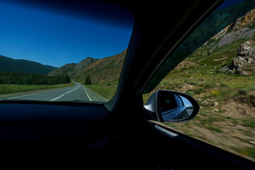 view from the window of the road, blue sky and mountains while driving while traveling in Altai