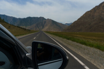 view from the window of the road, blue sky and mountains while driving while traveling in Altai