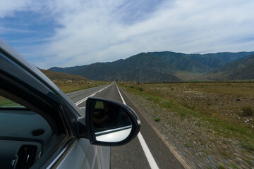 view from the window of the road, blue sky and mountains while driving while traveling in Altai