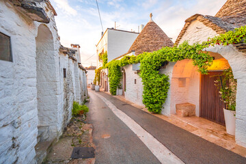 Trulli of Alberobello, Puglia, Italy. town of Alberobello with trulli houses among green plants and...