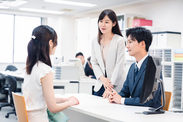 Obraz premium 窓口で来客の対応をするビジネスパーソン