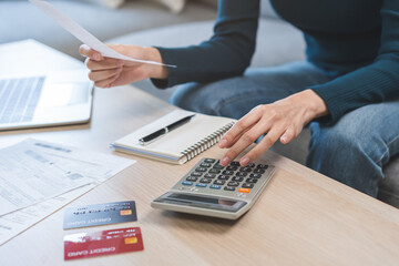 Stressed asian young business woman, employee using calculator to calculate expenses of monthly,...