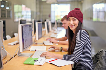 Happy woman, portrait and library with computer at university for education, learning or project. Online, scholarship and student at desk for browsing internet, knowledge or working on assignment