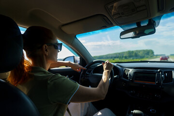 mature woman travels by car on the roads of Altai with mountains flashing outside the window
