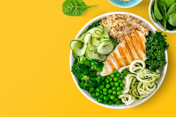 Healthy plate lunch with grilled chicken, zucchini pasta, green peas, broccoli, cucumber, bulgur...