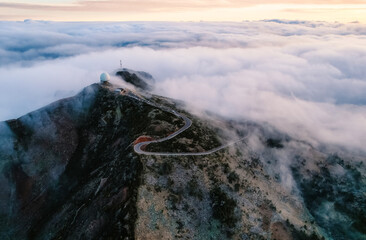 Aerial view of majestic mountain ridges at sunrise with falling fog from top of Pico do Areeiro,...