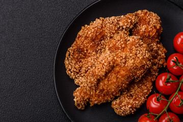 Delicious fresh crispy chicken nuggets on a dark concrete background