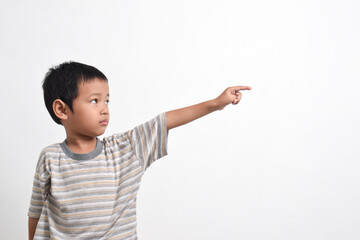 Image of Asian child posing scared and sad pointing towards the side on a white background. portrait of an Asian boy