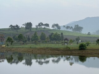landscape with lake in the foggy morning