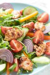 Healthy Salad with Chicken Breast, Cherry Tomatoes, Cucumber, Orange Pepper, Endive and Red Onion. Close up.
