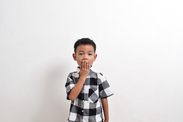 Image of Asian child posing covering his mouth with both hands on a white background. portrait of an Asian boy