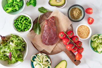 Fresh raw ingredients to preparation a healthy plate on on a marble background, beef tenderloin,...