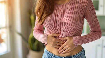 Gastrointestinal problems, a woman with a pink sweater holding her stomach in pain