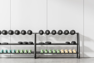 Stylish sport room interior with dumbbell rack on concrete floor