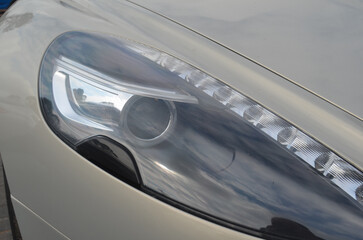 Fototapeta premium Car headlight close-up. Luxury vehicle detail of headlight.