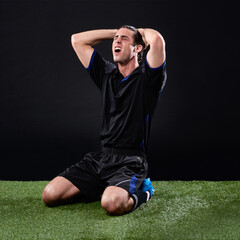 Field, soccer player and man in grass, angry and lose in game, stress and upset on ground and outdoor. Black background, sad and athlete with hands, unhappy and person with shouting fail in football