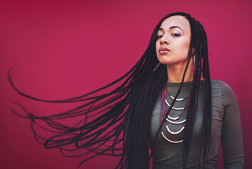 Woman, portrait and hair with braids, jewelry or cosmetics for fashion or beauty on a pink studio background. Attractive, young model or female person with long braided hairstyle, weave or extensions