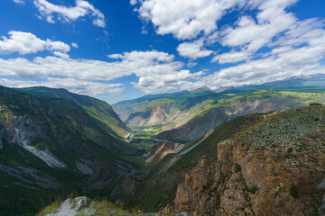 panorama of the landscape, Altai, pass, mountain slopes, valley, bends of the road, white clouds in the blue sky