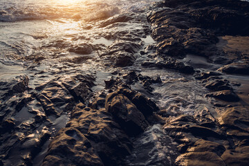 A large rocks surrounded by waves of the ocean