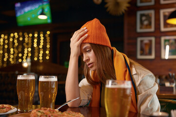 Frustrated sad woman football fan touching head due to loss of favorite team