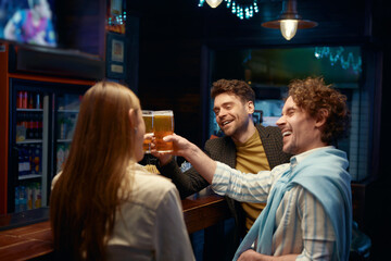 Guys employee congratulating female coworker while rest in bar