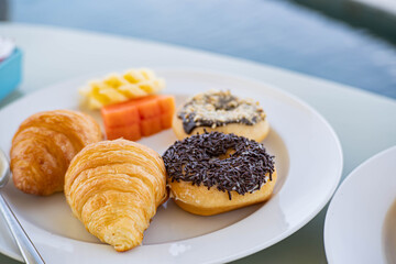 Breakfast plate with pastries and fruit near a pool