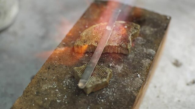 Heating with a flame jet of a metal billet of a silver ring. The work of a jeweler in the workshop
