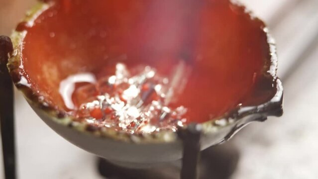 Heating with a flame jet of a metal billet of a silver ring. The work of a jeweler in the workshop