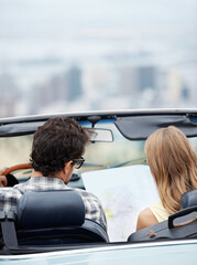 Car, couple and reading map for travel on road trip, vacation and plan holiday by back of...