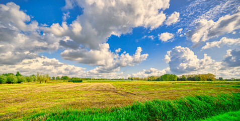 Big cloud formations passing over a rural landscape in The Netherlands.