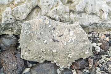 Beachrock is a friable to well-cemented sedimentary rock that consists of a variable mixture of basalt gravel , sand , and silt-sized sediment. fragments of coral and shells . Geology 
