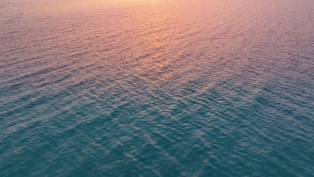 Flying over the ocean at sunset. Aerial view of drone flight over sea in sunset. Beautiful Aerial shot over the Ocean. 