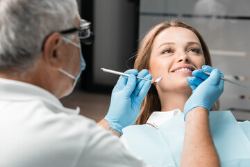 A patient is comfortably seated in the dental chair, whose bright smile adorns the office. The...