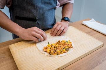 Chef at the kitchen preparing quesadillas with tofu and sweet corn