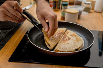 Chef at the kitchen preparing quesadillas with tofu and sweet corn