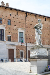 Statue by a building on a stone path in the province of Pesaro and Urbino