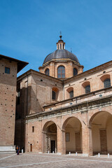 Man standing near a building with multiple arches in the province of Pesaro and Urbino