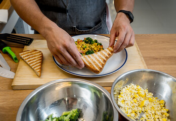 Chef at the kitchen preparing tofu scramble with vegetables