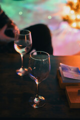 Close-up of wine glasses on a table with Christmas lights in the background