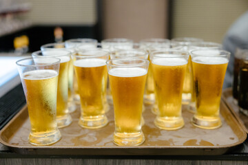 Cold draft beer in a glass to welcome guests at a festive party.